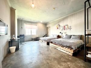 a bedroom with two beds and a desk in it at d'primahotel Yogyakarta in Yogyakarta