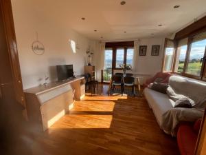 a living room with a couch and a television at Apartamentos Casa Carmen in Suances