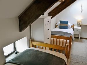 two beds in a room with a attic at Granary Barn in Marros +14 photos