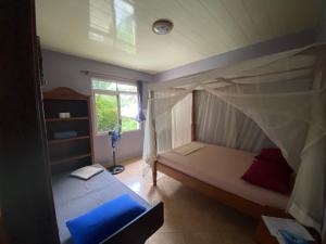 a bedroom with a canopy bed and a window at Fare Om in Pihaena +45 photos