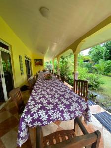 a dining room with a purple table and chairs at Fare Om in Pihaena
