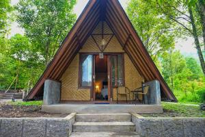 a small house with a triangular roof with stairs at Livin didesa in Munduk