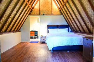 a bedroom with a bed and a wooden floor at Livin didesa in Munduk