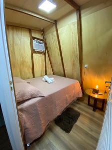 a small bed in a room with a table at Tiny House in Boa Vista
