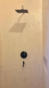 a clock on the side of a wall with a spotlight at Ayu Homestay - Room 4 in San Isidro