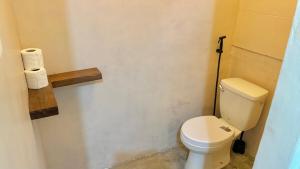 a bathroom with a toilet and some toilet paper at Ayu Homestay - Room 4 in San Isidro