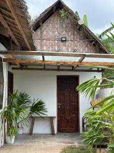 a house with a wooden door and some plants at Ayu Homestay - Room 4 in San Isidro