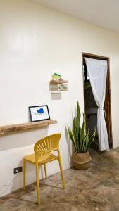 a yellow chair and a table and a plant at Ayu Homestay - Room 4 in San Isidro