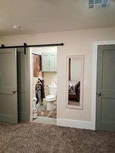a bathroom with a toilet and a mirror at Xscapecatio Oasis II in Tulsa +6 photos