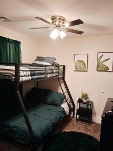 a bedroom with a bunk bed and a ceiling fan at Xscapecatio Oasis II in Tulsa