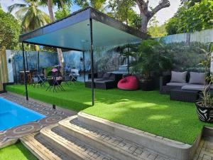 a garden with grass and a pavilion next to a pool at White Summerville Tourist Inn in Busuanga