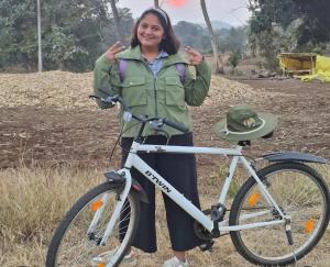 a woman is standing next to a bike at Home in the Jungle Pench in Seonī