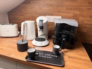 a counter with coffee makers and cups on it at Appartement jacuzzi et spa étoile Mystérieuse in Belfort +9 photos