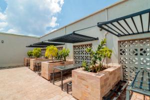 a patio with a row of tables and plants at Residence Next Door Sunset in Kiambu