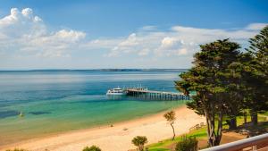 a boat is docked at a pier on a beach at Cowes Beachfront Penthouse in Cowes