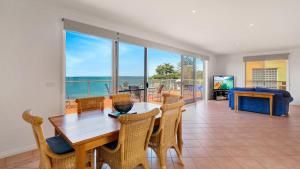 a dining room with a table and chairs and a view of the ocean at Cowes Beachfront Penthouse in Cowes