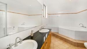 a white bathroom with two sinks and a tub at Cowes Beachfront Penthouse in Cowes +12 photos