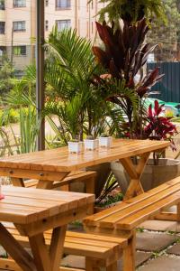 a wooden picnic table and benches in a courtyard at Residence Next Door Sunset in Kiambu +5 photos