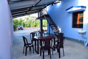 a patio with a table and chairs and a staircase at SugarLeaf Homestay - Home Food & Near to Tourist Places in Sakleshpur