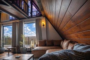 a living room with a couch and large windows at Kubana in Nuwara Eliya