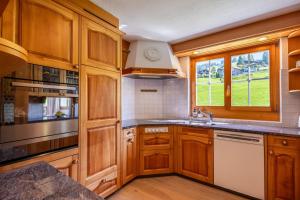 a kitchen with wooden cabinets and a sink at Villa mit Seeblick in Amden