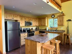 a kitchen with wooden cabinets and a stainless steel refrigerator at Creekside Cabin - Ski Chalet in Packwood