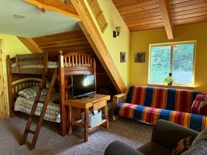 a bedroom with two bunk beds and a couch at Creekside Cabin - Ski Chalet in Packwood