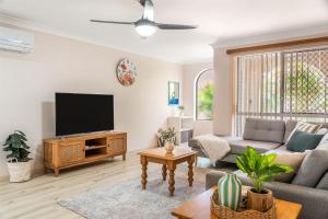 a living room with a couch and a tv at Waratah Retreat in Evans Head