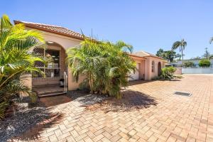 a house with palm trees in front of a driveway at Waratah Retreat in Evans Head