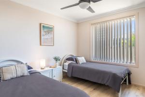 two beds in a room with a window at Waratah Retreat in Evans Head