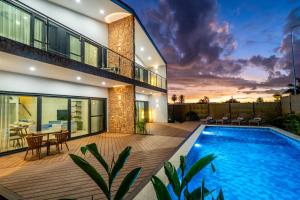 a house with a swimming pool and a deck at Tides Apartments in Nadi
