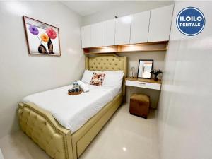 a small bedroom with a bed and a desk at Modern Style 2-BR in SMDC in Iloilo City +7 photos