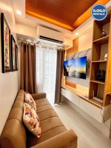 a living room with a couch and a flat screen tv at Modern Style 2-BR in SMDC in Iloilo City