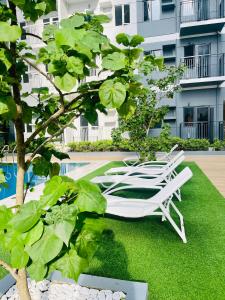 a white lounge chair on the grass next to a building at Modern Style 2-BR in SMDC in Iloilo City