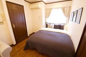 a bedroom with a large bed with a window at Forest Inokashira in Mitaka