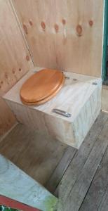 a wooden toilet with a wooden seat in a box at Surf Shack on Broadway in Waitara +24 photos