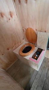 a bathroom with a toilet in a wooden house at Surf Shack on Broadway in Waitara