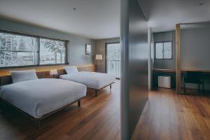 a hotel room with two beds and a desk at Villa El Cielo Myoko in Myoko +41 photos