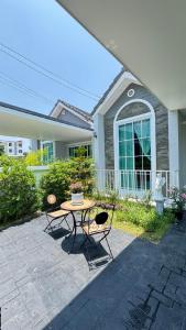 a table and chairs in front of a house at บ้านมั่งมี ขอนแก่น in Ban Si Than