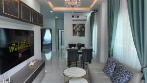 a living room with a couch and a table at บ้านมั่งมี ขอนแก่น in Ban Si Than
