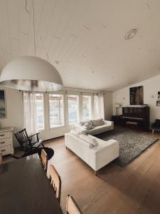 a living room with a white couch and a piano at Beautiful Home in Sipoo in Söderkulla