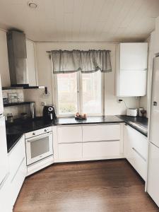 a kitchen with white cabinets and a window at Beautiful Home in Sipoo in Söderkulla