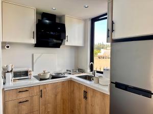 a kitchen with white cabinets and a large window at Sunkissed Haven - Coastal Escape in Flic-en-Flac