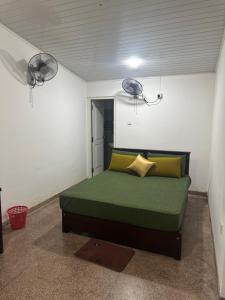 a bedroom with a green bed in a room with two lights at Solace More Hotel - Borella 2 in Colombo