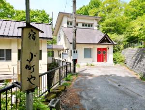 a house with a red door and a driveway at 宿小町や in Senboku