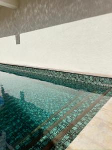 a swimming pool with a reflection in the water at Sunkissed Haven - Coastal Escape in Flic-en-Flac