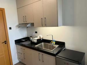 a kitchen with a sink and a counter top at Wide studio Antara Residences Talisay in Talisay +11 photos