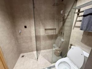 a bathroom with a glass shower with a toilet at Wide studio Antara Residences Talisay in Talisay
