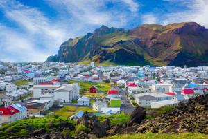a view of a town with mountains in the background at Luxury Ocean Villas in Vestmannaeyjar