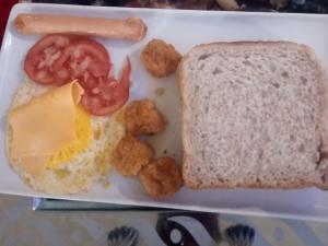 ein Teller Frühstücksspeise mit Eiern, Brot und Tomaten in der Unterkunft GenAyah Hotel & Safari in Mtimba + 65 Fotos